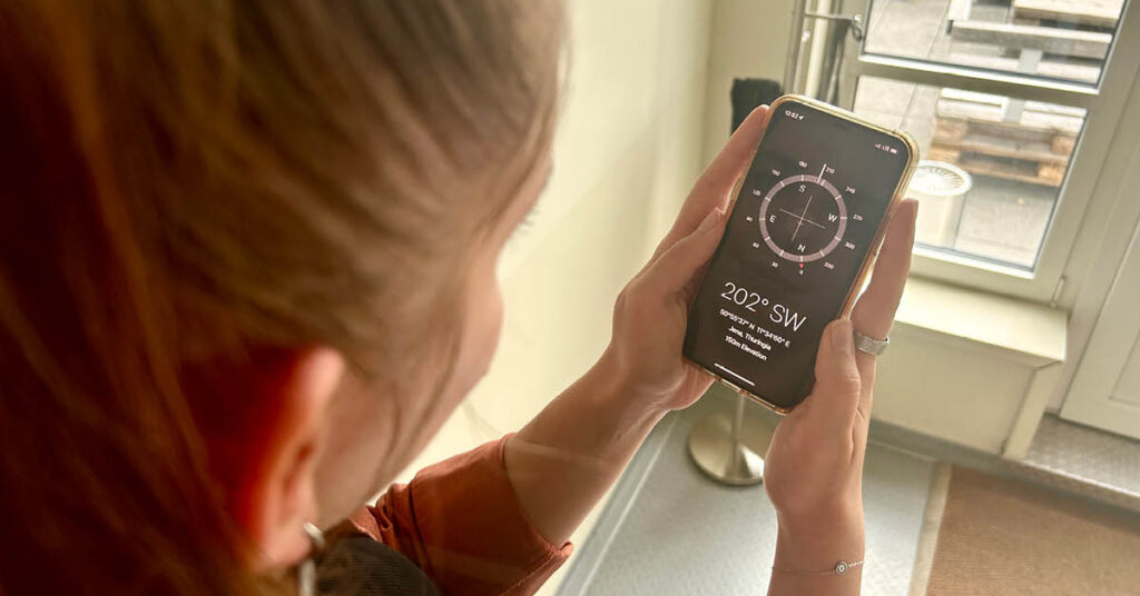 A person using a compass app on their phone, symbolising the importance of navigating decisions with data-driven insights.