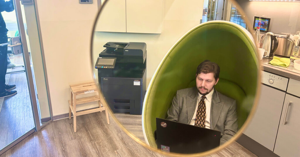 Mirror image of a man hard at work on his laptop.