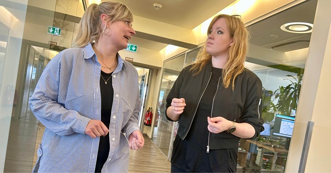Two colleagues engaged in discussion, capturing how collaboration drives impactful digital strategies.