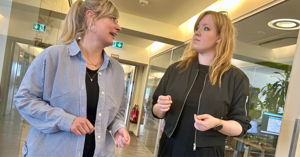 Two colleagues engaged in discussion, capturing how collaboration drives impactful digital strategies.