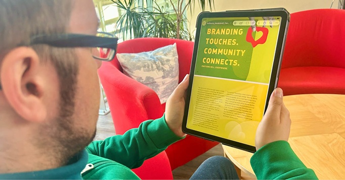 Person holding a tablet in a relaxed office environment, reading the Handelskraft Trend Book on the future of digital business.