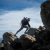 Hiker or backpacker climbing mountainous terrain with rocks